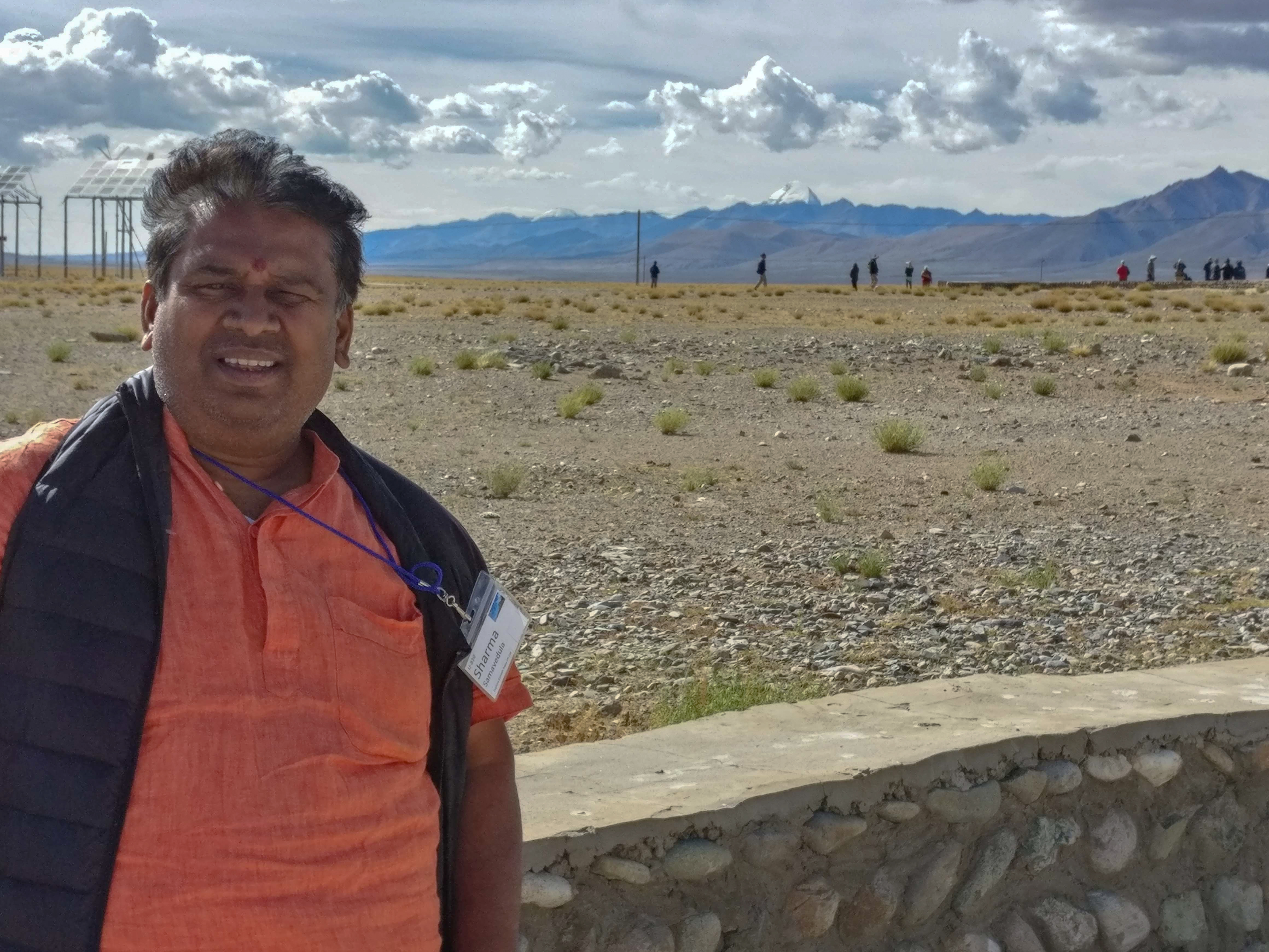 Pundit Samavedula stands near a wall with Mount Kailish in the far background in 2018.